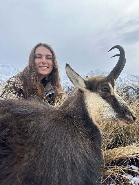 A hunter close beside her chamois in the high country